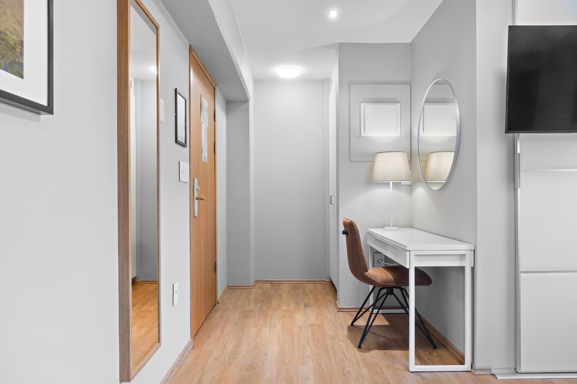 Entrance hallway with desk, mirror and wardrobe in a triple room at START Hostel