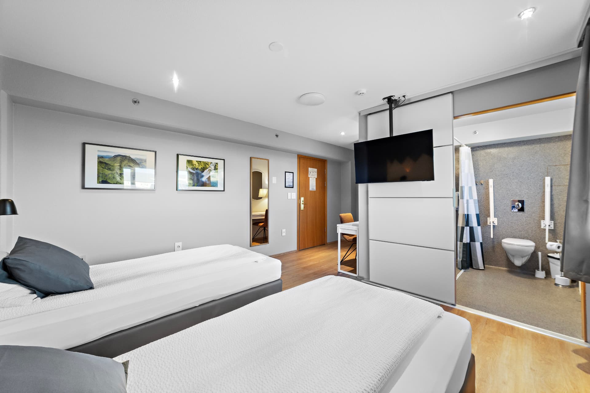 Triple room with private bathroom — twin beds, wall-mounted TV and en-suite shower at START Hostel