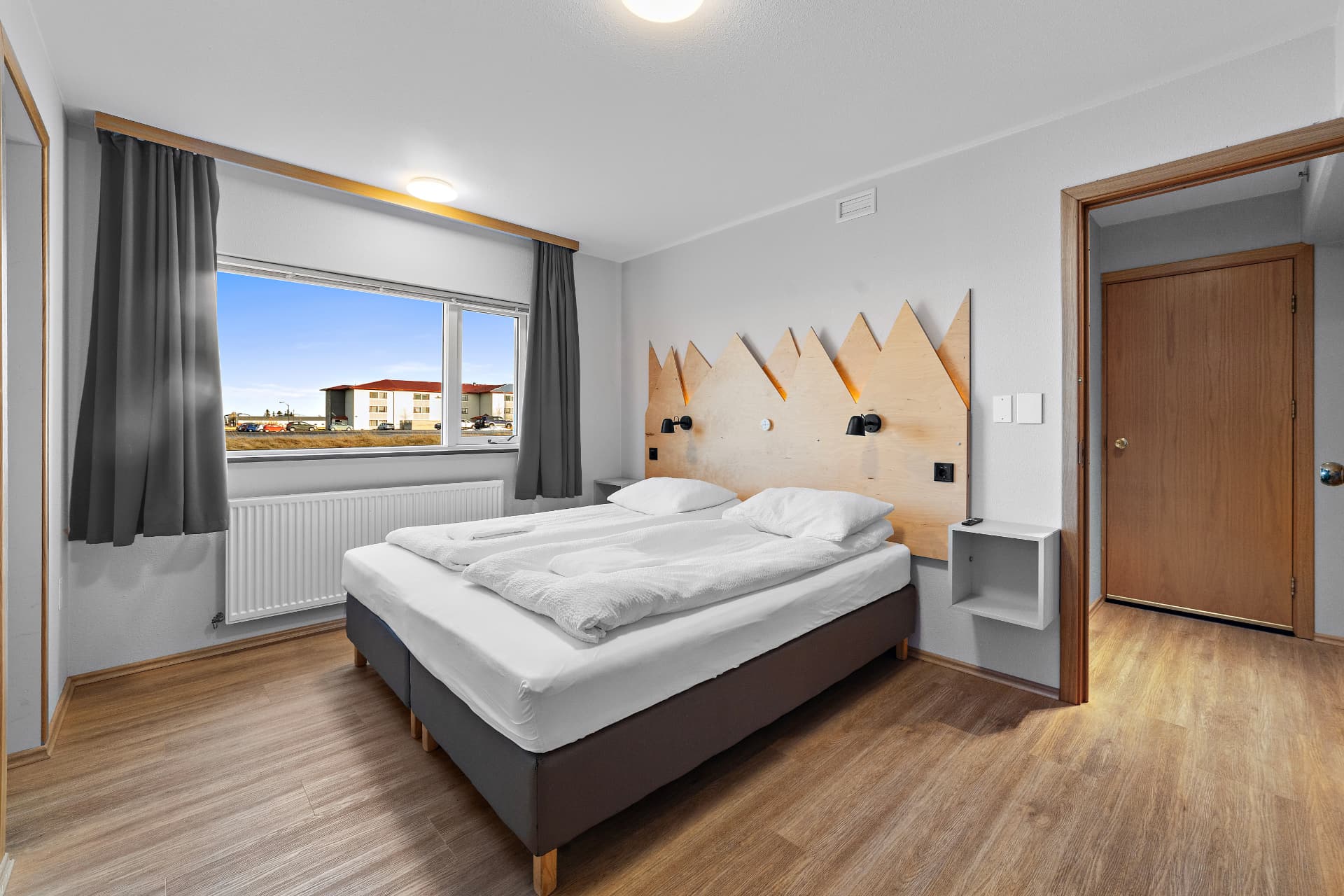 Double room with shared bathroom and mountain-shaped wooden headboard at START Hostel