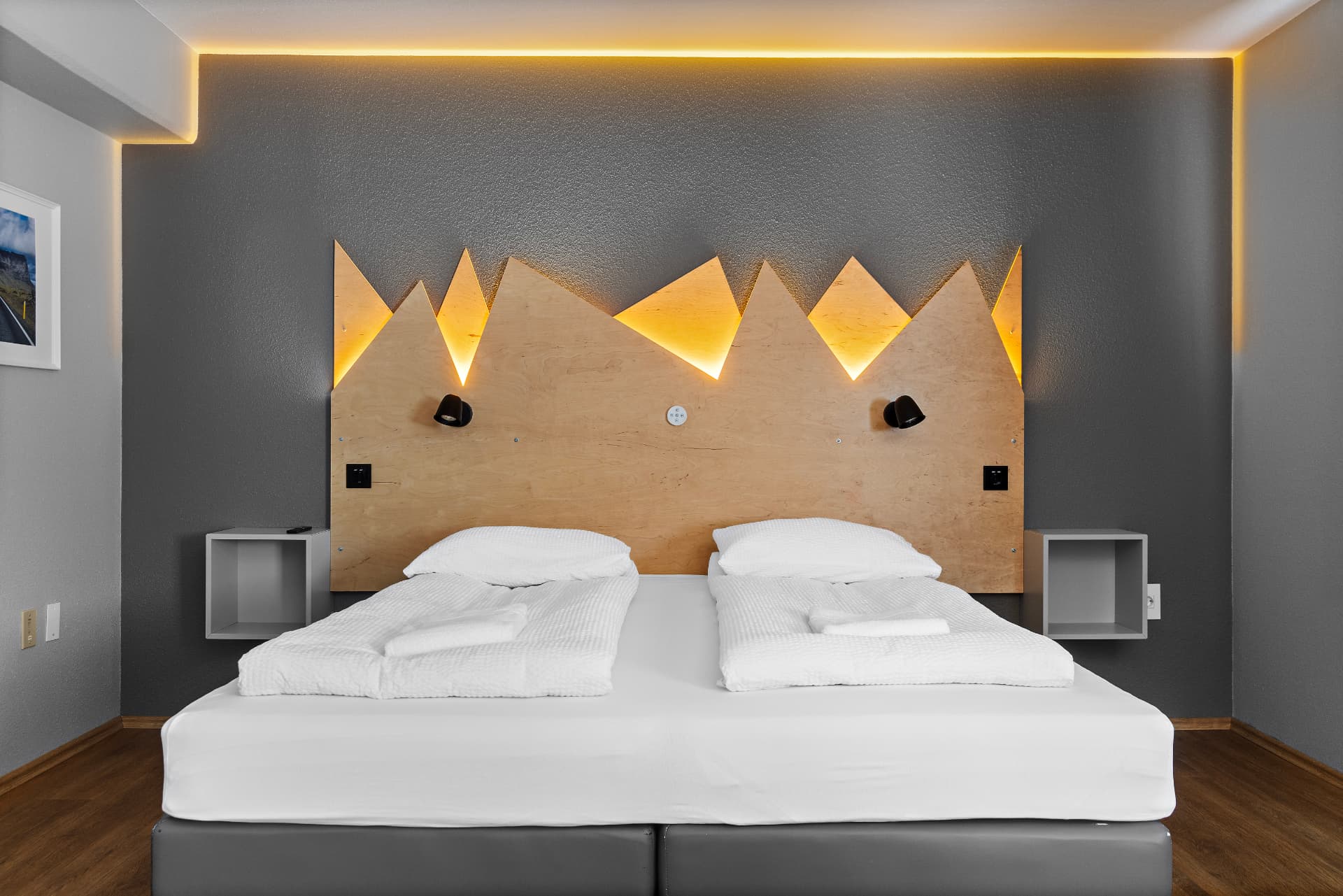 Twin beds with backlit mountain headboard in a room with shared bathroom at START Hostel