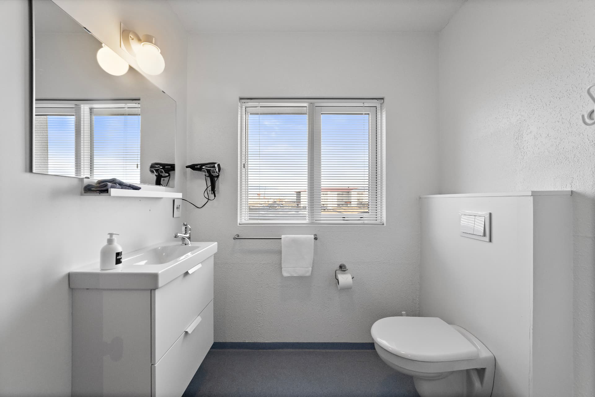 Private bathroom with sink, mirror, hairdryer and window at START Hostel